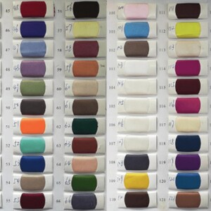 K&ouml;nnte beinhalten: Eine Farbkarte mit 66 Stoffmustern. Die Muster sind in Reihen und Spalten angeordnet. Die Muster sind in verschiedenen Farben, darunter Rot, Blau, Gr&uuml;n, Gelb und Orange.