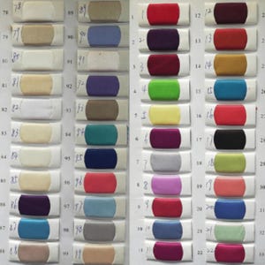 K&ouml;nnte beinhalten: Eine Farbkarte mit 39 Stoffmustern. Die Muster sind in Reihen und Spalten angeordnet. Die Farben reichen von Dunkelgr&uuml;n bis Hellrosa.