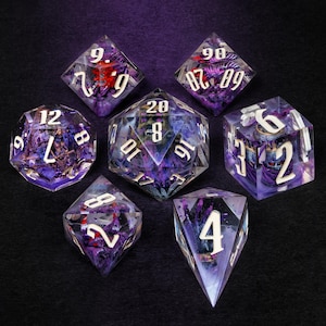 May include: A set of seven polyhedral dice, each with a purple and clear resin design. The dice feature white numbering and internal details. Ideal for tabletop role-playing games.