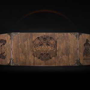 Może przedstawiać: Drewniany ekran do gier RPG ze śladem po bejcy. Posiada grawerowane grafiki czarodzieja, smoka i kości. Tekst "CHOOSE YOUR WEAPON" jest r&oacute;wnież wygrawerowany. Metalowe narożniki trzymają ekran razem. Do gier planszowych.