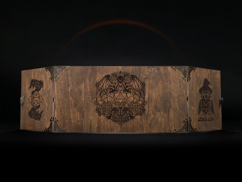 Może przedstawiać: Drewniany ekran do gier RPG ze śladem po bejcy. Posiada grawerowane grafiki czarodzieja, smoka i kości. Tekst "CHOOSE YOUR WEAPON" jest r&oacute;wnież wygrawerowany. Metalowe narożniki trzymają ekran razem. Do gier planszowych.
