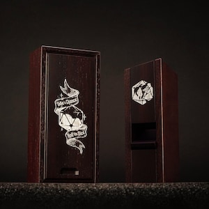 May include: Two dark brown wooden boxes with white etched designs. One box has a banner with the text "Take a Chance Roll the Dice" and a die graphic. The other box has a geometric design.