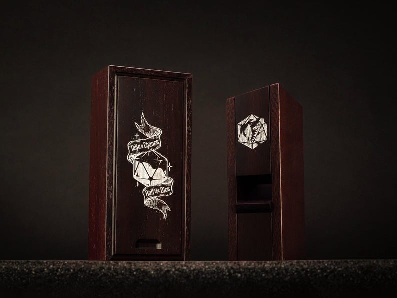 May include: Two dark brown wooden boxes with white etched designs. One box has a banner with the text "Take a Chance Roll the Dice" and a die graphic. The other box has a geometric design.