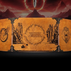 K&ouml;nnte beinhalten: Ein h&ouml;lzerner Spielbildschirm zum Thema Herr der Ringe. Der Bildschirm besteht aus drei Tafeln mit schwarz ge&auml;tzten Kunstwerken und Texten. Die Kunstwerke umfassen das Auge von Sauron, Figuren und die Inschrift des Einen Rings. Die Tafeln sind mit schwarzen Metallscharnieren verbunden.