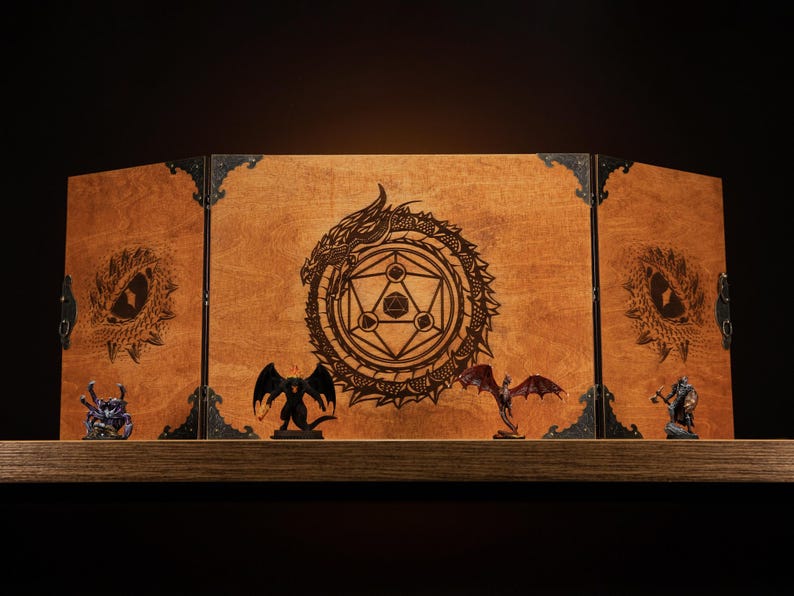 Może przedstawiać: Drewniany ekran do gier stołowych z motywem smoka i geometrycznym wzorem. Ekran jest brązowy z czarnymi metalowymi zawiasami. Miniaturowe figurki fantasy są wystawione przed ekranem.