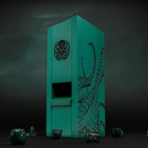 May include: A teal dice tower featuring a black tentacle design and a decorative emblem. Several green and gold dice are scattered around the base of the tower, creating a thematic tabletop gaming scene.
