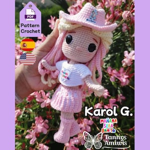 May include: A handmade crochet doll with pink hair and a matching cowboy hat. The doll is wearing a white shirt and a pink skirt. The text "Karol G." is displayed, along with the words "Mañana Será Bonito" and "Tannys Amiwis".
