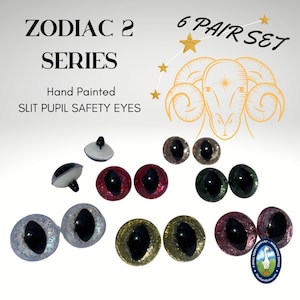 May include: Six pairs of hand-painted, glitter safety eyes with slit pupils. The eyes are in various colors, including red, green, gold, and silver. The image also includes a zodiac symbol for Aries, a ram.