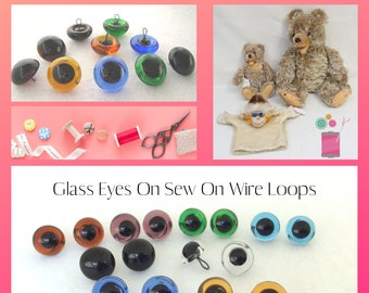 Peut inclure: Assortiment d'yeux en verre avec des boucles de fil pour coudre sur des animaux en peluche. Les yeux sont de différentes couleurs, notamment marron, noir, vert, bleu et transparent. L'image montre également un gros plan des yeux et une paire d'ours en peluche.