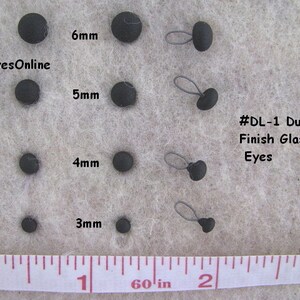 Op de afbeelding: Assortiment zwarte glazen ogen voor knutselen, vari&euml;rend in grootte van 3 mm tot 6 mm. De ogen zijn gelabeld met hun grootte in millimeters en zijn gelabeld #DL-1 Matte Glas Ogen.