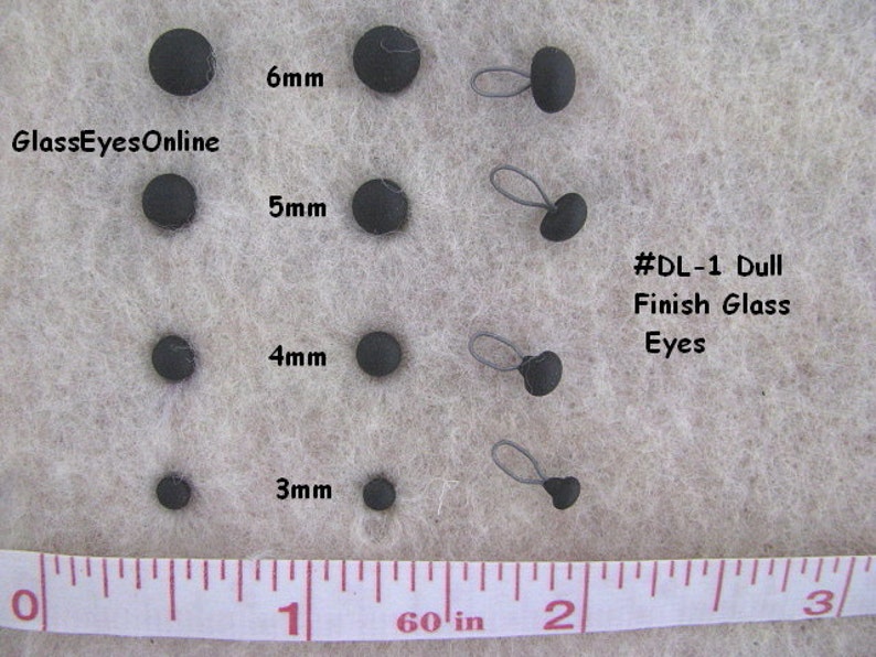 Op de afbeelding: Assortiment zwarte glazen ogen voor knutselen, vari&euml;rend in grootte van 3 mm tot 6 mm. De ogen zijn gelabeld met hun grootte in millimeters en zijn gelabeld #DL-1 Matte Glas Ogen.