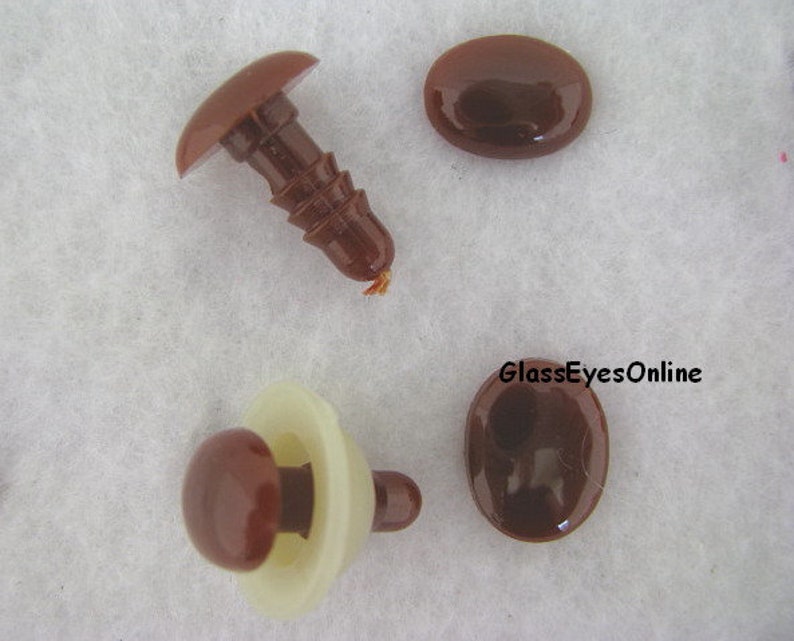 May include: Four brown plastic safety eyes for crafts. Two eyes are flat and two eyes are attached to a plastic post.