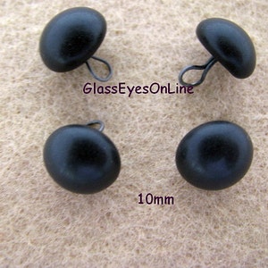 May include: Four black plastic buttons with a metal loop on the back. Each button is 10mm in diameter. GlassEyesOnline.