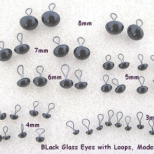 K&ouml;nnte beinhalten: Schwarze Glasaugen mit Schlaufen in verschiedenen Gr&ouml;&szlig;en, von 3 mm bis 8 mm. Die Augen sind dunkel und haben eine Metallschlaufe. Der Text "Black Glass Eyes with Loops, Model LP201" ist im Bild enthalten.