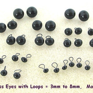 K&ouml;nnte beinhalten: Eine Sammlung schwarzer Glasaugen mit Schlaufen, in Gr&ouml;&szlig;en von 3 mm bis 8 mm. Die gl&auml;nzenden, kugelf&ouml;rmigen Augen sind in verschiedenen Gr&ouml;&szlig;en angeordnet, mit kleinen Drahtschlaufen. Der Text unten lautet "Black Glass Eyes with Loops = 3mm to 8mm, Model LP201."