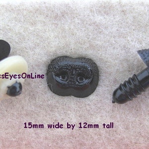 May include: Three black plastic safety eyes for stuffed animals. The eyes are 15mm wide and 12mm tall. The eyes have a screw-on back and a textured surface. The text "GlassEyesOnLine" is visible in the image.