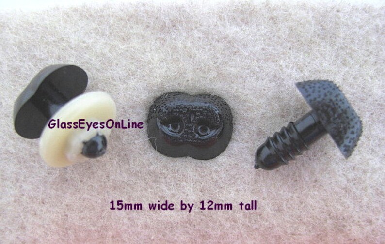 May include: Three black plastic safety eyes for stuffed animals. The eyes are 15mm wide and 12mm tall. The eyes have a screw-on back and a textured surface. The text "GlassEyesOnLine" is visible in the image.