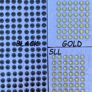 May include: A sheet of black and gold self-adhesive googly eyes. The sheet is divided into three sections, labeled "BLACK", "GOLD", and "SLL".