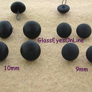 May include: Assortment of black plastic buttons in two sizes, 9mm and 10mm. The buttons are round and have a smooth, matte finish.  GlassEyesOnLine is printed on the surface.