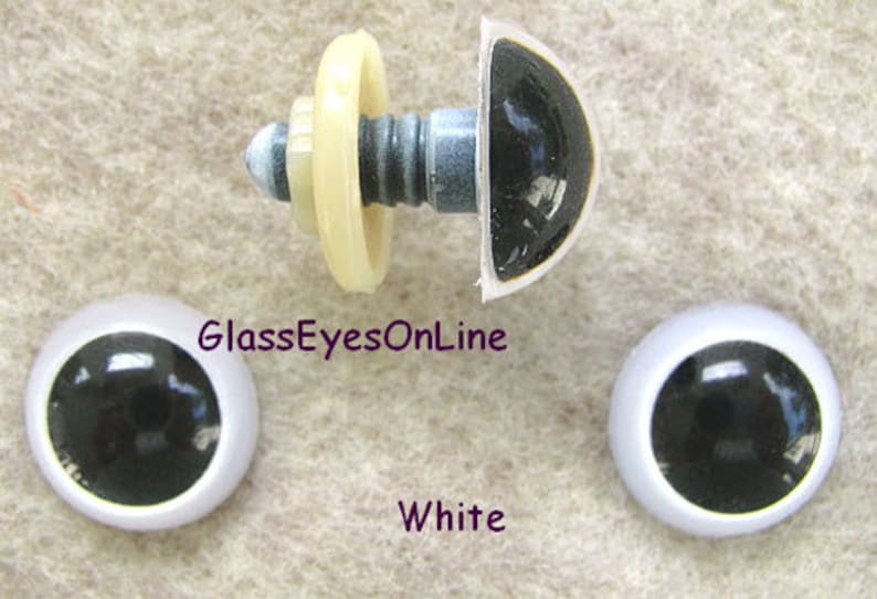 May include: Three black plastic safety eyes with white plastic rims. The eyes are 12mm in diameter. The eyes are on a white background. GlassEyesOnLine and White are written in purple text.