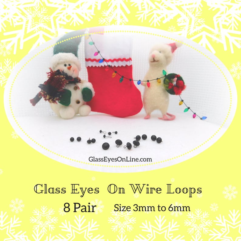 May include: Eight pairs of black glass eyes on wire loops, scattered on a white surface. The eyes range in size from 3mm to 6mm. A snowman and a white mouse are in the background, with a red stocking and Christmas lights.
