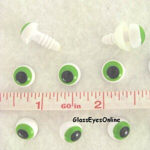 May include: Green and black plastic safety eyes with white backs, measuring 1 inch in diameter. The eyes are shown next to a ruler and two sets of eye fasteners.