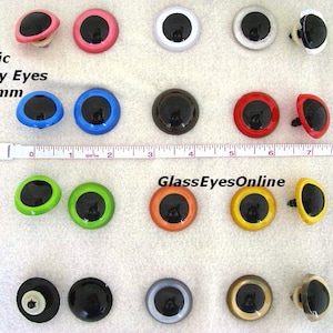May include: Assortment of 30mm plastic safety eyes in various colours, including black, white, red, blue, green, orange, yellow, brown, and silver. The eyes have a black pupil and a white or coloured ring around the pupil. The eyes are attached to a plastic post with a washer.