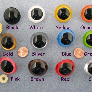 May include: Assortment of 34mm plastic safety eyes in various colours, including black, white, yellow, orange, gold, silver, blue, green, pink, brown, red, and clear. The eyes have a black pupil and a white ring around the pupil.