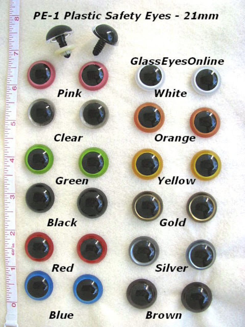 May include: Assortment of 21mm plastic safety eyes in various colours, including black, white, pink, orange, yellow, green, red, blue, brown, silver, and gold. PE-1 Plastic Safety Eyes - 21mm. GlassEyesOnline.