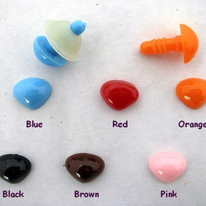 May include: Assortment of colorful plastic safety eyes for crafts. The eyes are in various colors, including blue, red, orange, black, brown, and pink. The eyes are in a heart shape and have a flat back.