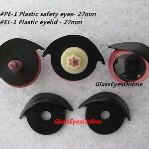 May include: Four plastic safety eyes and eyelids for crafts. Two black plastic safety eyes with pink eyelids and two black plastic eyelids. The eyes are 27 mm in diameter. The text on the image reads "#PE-1 Plastic safety eyes - 27mm #EL-1 Plastic eyelid - 27mm GlassEyesOnline".
