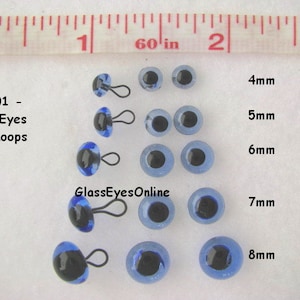 May include: Assortment of blue glass eyes with black pupils and metal loops. The eyes are arranged in rows by size, from 4mm to 8mm. The text #LP201 - Glass Eyes with Loops - Blue and GlassEyesOnline is visible in the image.