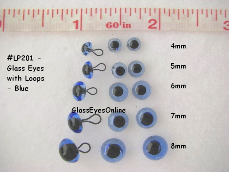 May include: Assortment of blue glass eyes with black pupils and metal loops. The eyes are arranged in rows by size, from 4mm to 8mm. The text #LP201 - Glass Eyes with Loops - Blue and GlassEyesOnline is visible in the image.