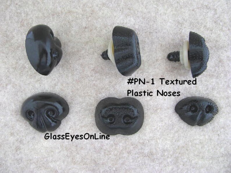 May include: Five black plastic noses for doll making or craft projects. The noses have a textured surface and come in different shapes and sizes. #PN-1 Textured Plastic Noses