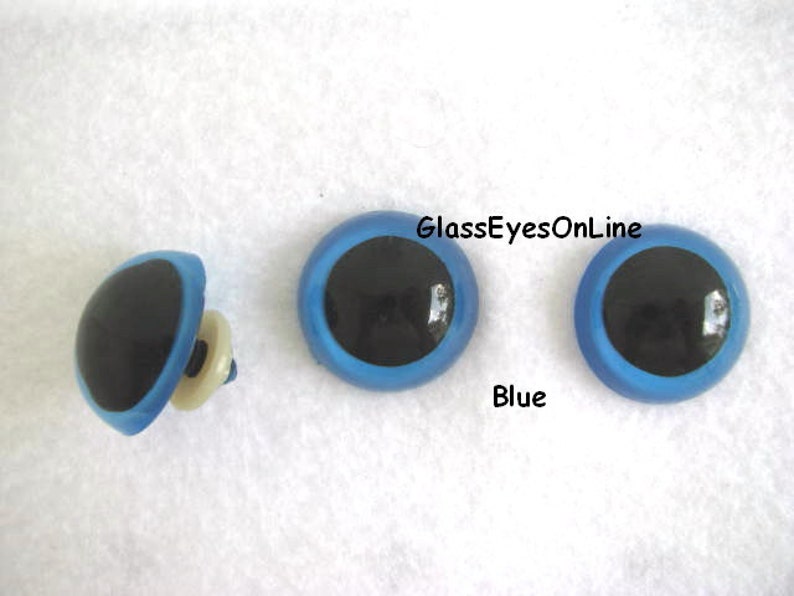 May include: Three blue plastic safety eyes with black pupils. The eyes are 1 inch in diameter. GlassEyesOnLine is printed on the image.