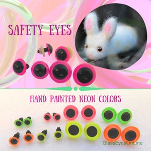 May include: Assortment of safety eyes in various sizes and neon colors, including pink, green, yellow, and orange. The eyes are hand-painted and have black pupils. The text "SAFETY EYES" and "HAND PAINTED NEON COLORS" is visible in the image.