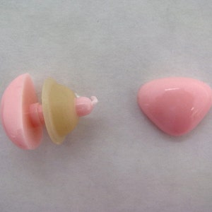 Pode incluir: Um conjunto de olhos de seguran&ccedil;a de pl&aacute;stico rosa para artesanato. Os olhos s&atilde;o vendidos em duas pe&ccedil;as, uma parte de tr&aacute;s plana e uma parte frontal em forma de c&uacute;pula. Os olhos t&ecirc;m um di&acirc;metro de aproximadamente 2,5 cm.