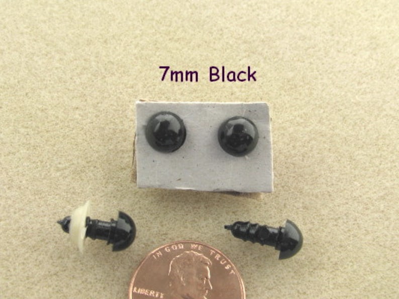 May include: Two black plastic safety eyes, 7mm in diameter, on a white card with the text "7mm Black".