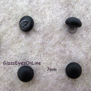 May include: Four black glass buttons with a 7mm diameter. The buttons have a shank on the back for sewing.