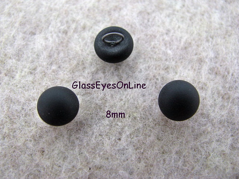 May include: Three black glass eyes with a metal shank for sewing. The eyes are 8mm in diameter.
