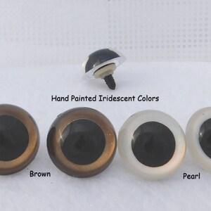 May include: Three plastic safety eyes for crafts, with black pupils and iridescent finishes. The eyes are shown in brown, gold, and pearl colors.  Hand Painted Iridescent Colors. Brown, Pearl.