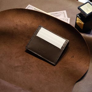 Tarjetero de piel marrón oscuro con compartimento para monedas