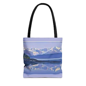 May include: A tote bag featuring a scenic landscape with snow-capped mountains, a lake, and reflections. The bag has a light purple border and a black handle. The artwork is a digital painting with a soft, painterly style.