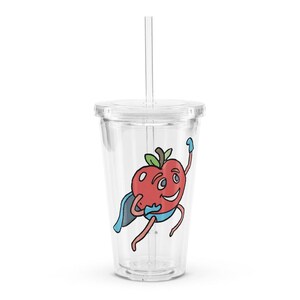May include: A clear plastic tumbler with a lid and straw. The tumbler has a cartoon image of a red apple with a blue cape and a smiling face. The apple is wearing a blue cape and has a blue glove on one hand.