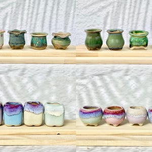May include: Assortment of ten small ceramic planters in various colours and styles. The planters are arranged in two rows of five. The planters are all approximately 2 inches in diameter.