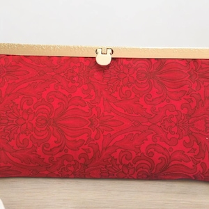 Sleek Red Clutch Wallet with Gold Tone Closure and Scroll Design