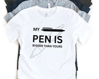 May include: A white t-shirt with a black graphic that says "My pen is bigger than yours" with a drawing of a pen.