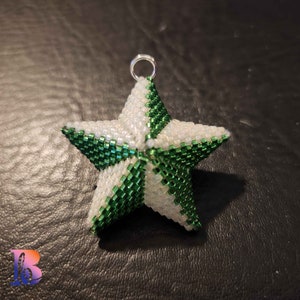 Könnte beinhalten: Ein grüner und weißer Perlenstern-Anhänger mit einer silbernen Schlaufe zum Aufhängen.