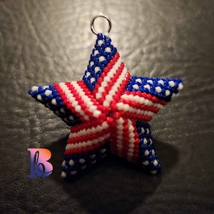 May include: A red, white, and blue beaded star ornament with a silver loop at the top.