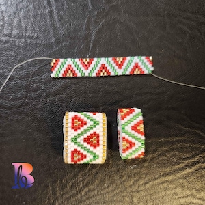 Op de afbeelding: Een witte kralen armband met een rood, groen en gouden geometrisch patroon. De armband is gemaakt van kleine kralen en is geregen op een dun draad. De armband wordt in drie delen getoond, met twee kleinere delen aan weerszijden van een groter deel.